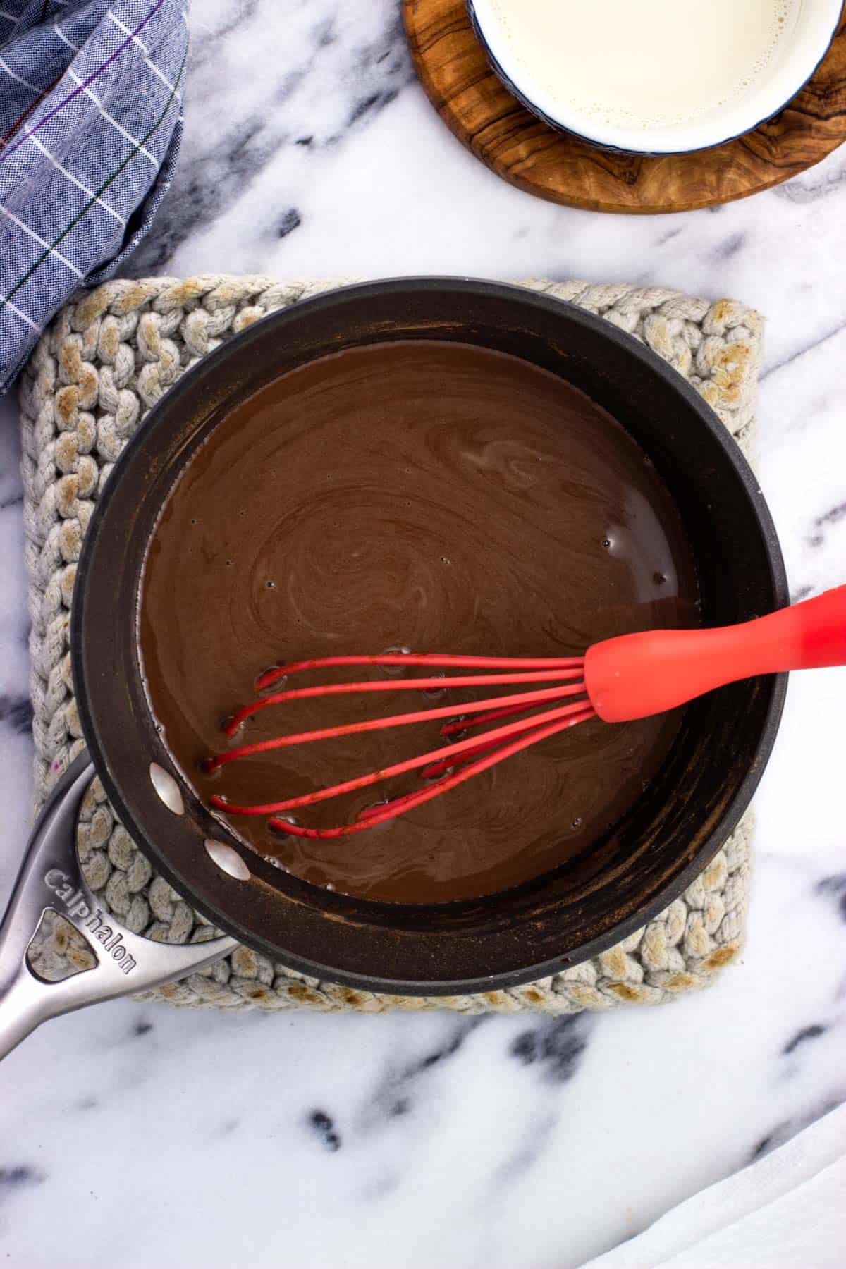 Smooth heated milk and cocoa, sugar, and salt in a pan with a whisk.