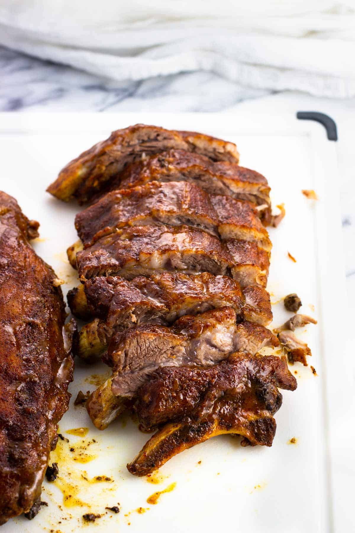 A half-rack of ribs sliced on a cutting board.