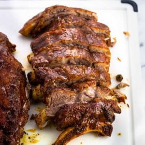 A half-rack of ribs sliced on a cutting board.