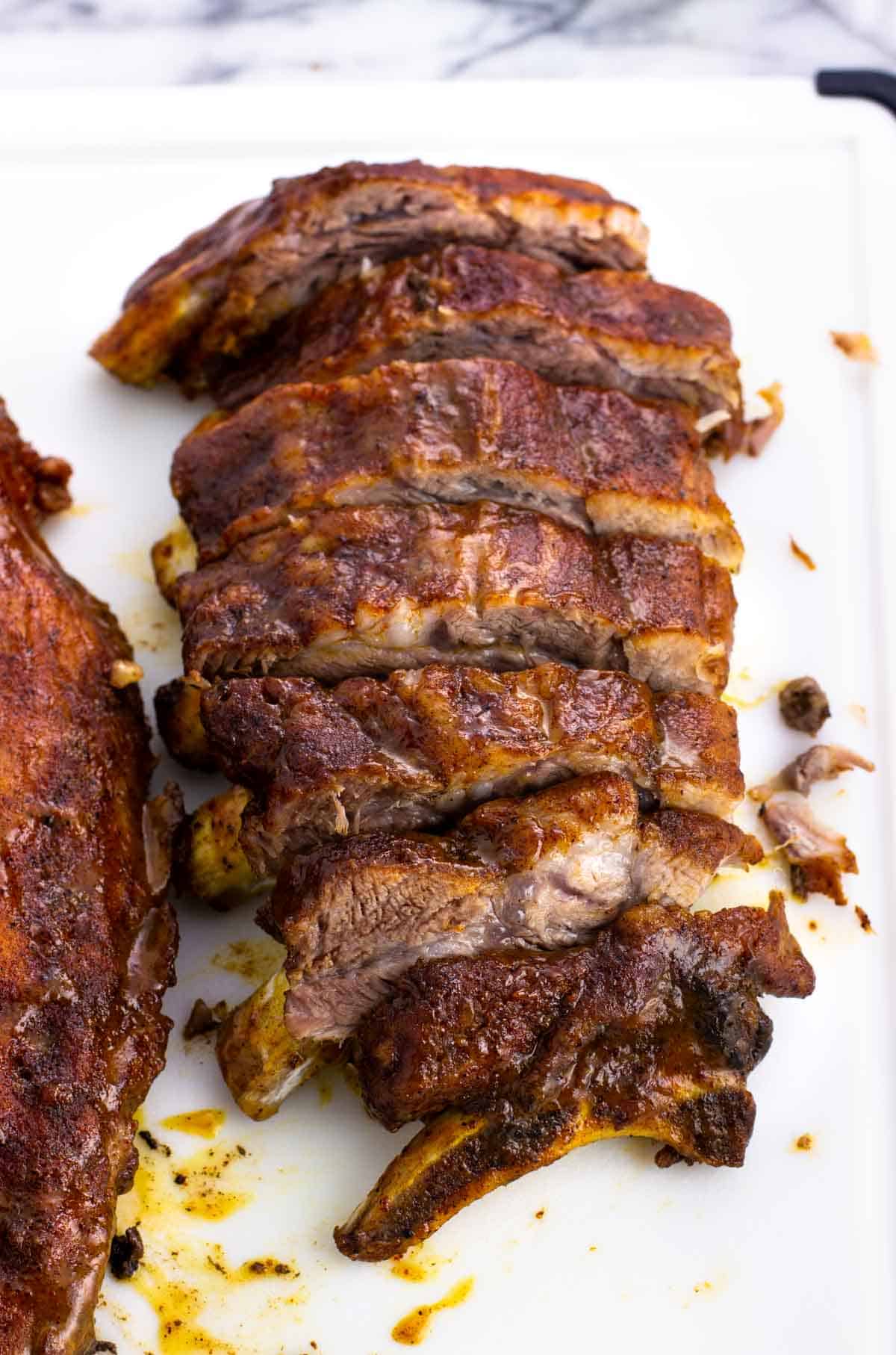 A half-rack of ribs sliced on a cutting board.