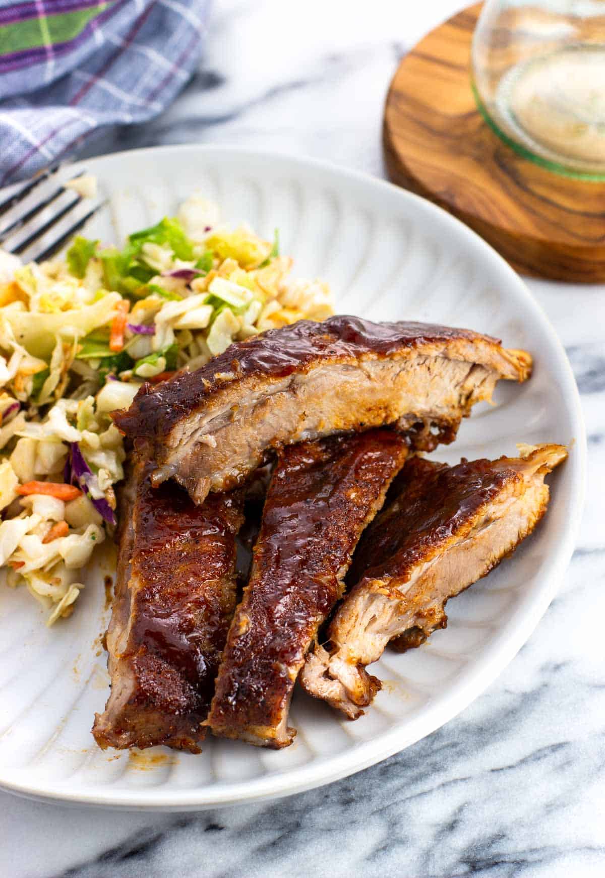 BBQ sauced ribs on a plate with salad.