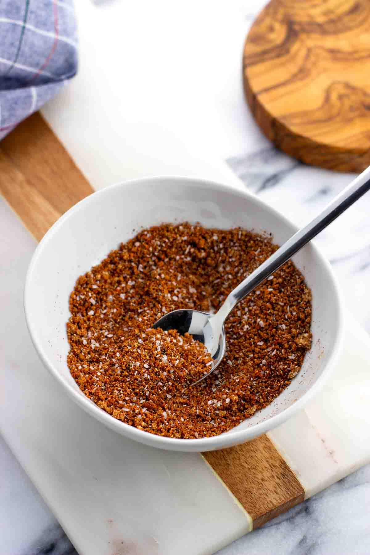 Combined spice rub ingredients in a bowl with a spoon.