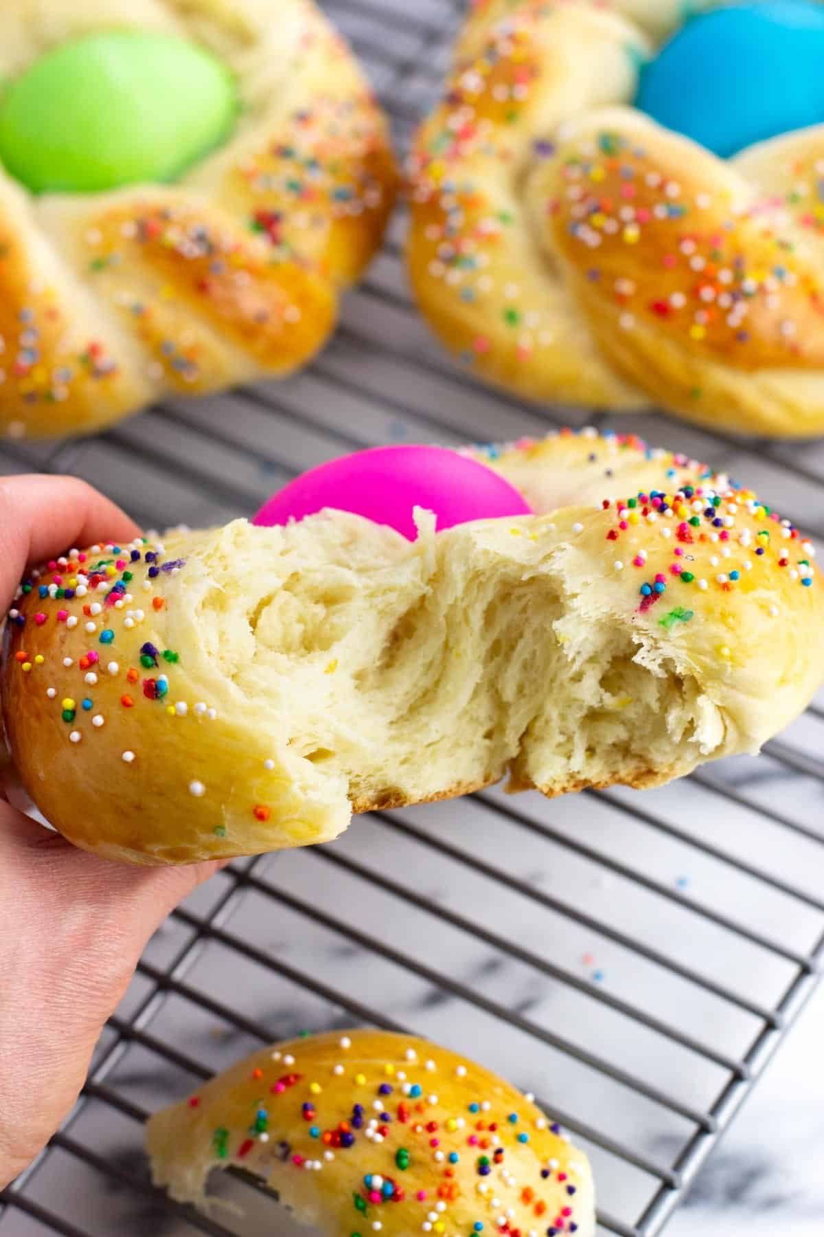 A hand holding up a sliced-open section of the fluffy bread.