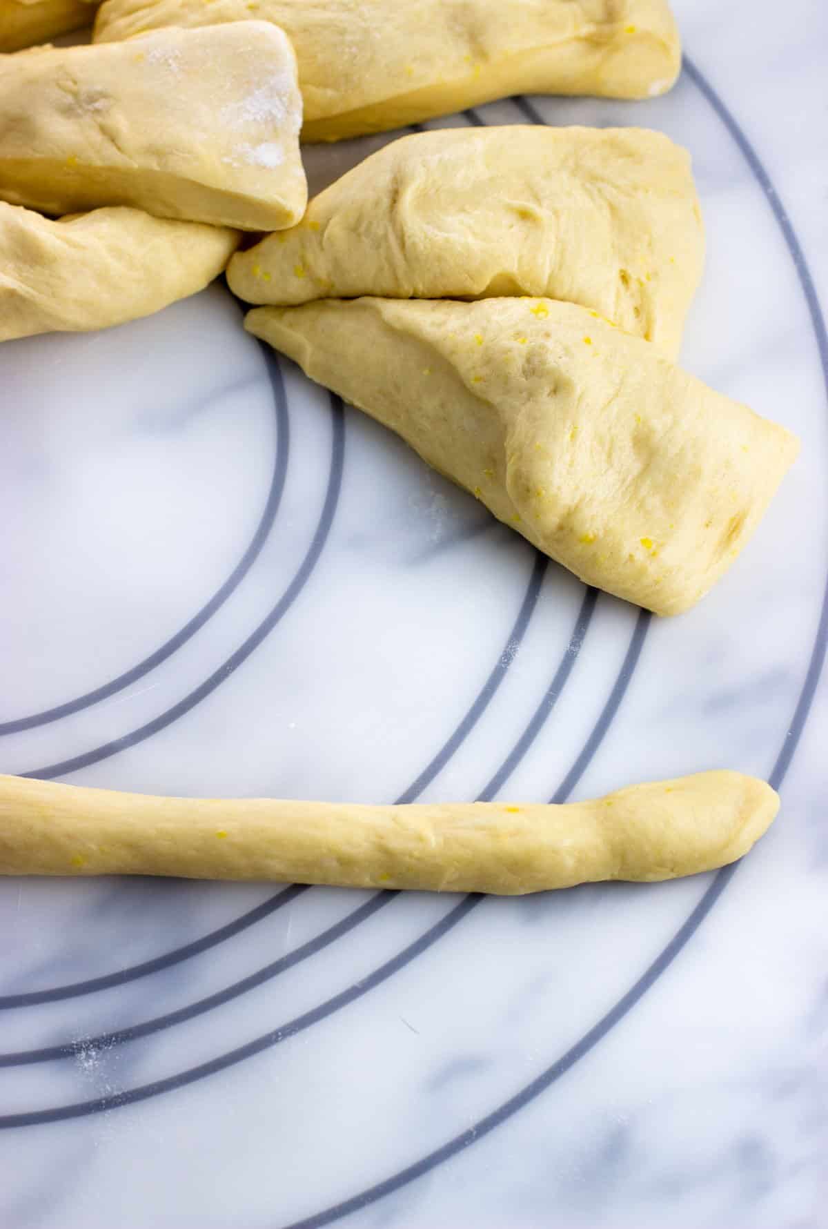 One of the pieces of dough rolled into a thin log.