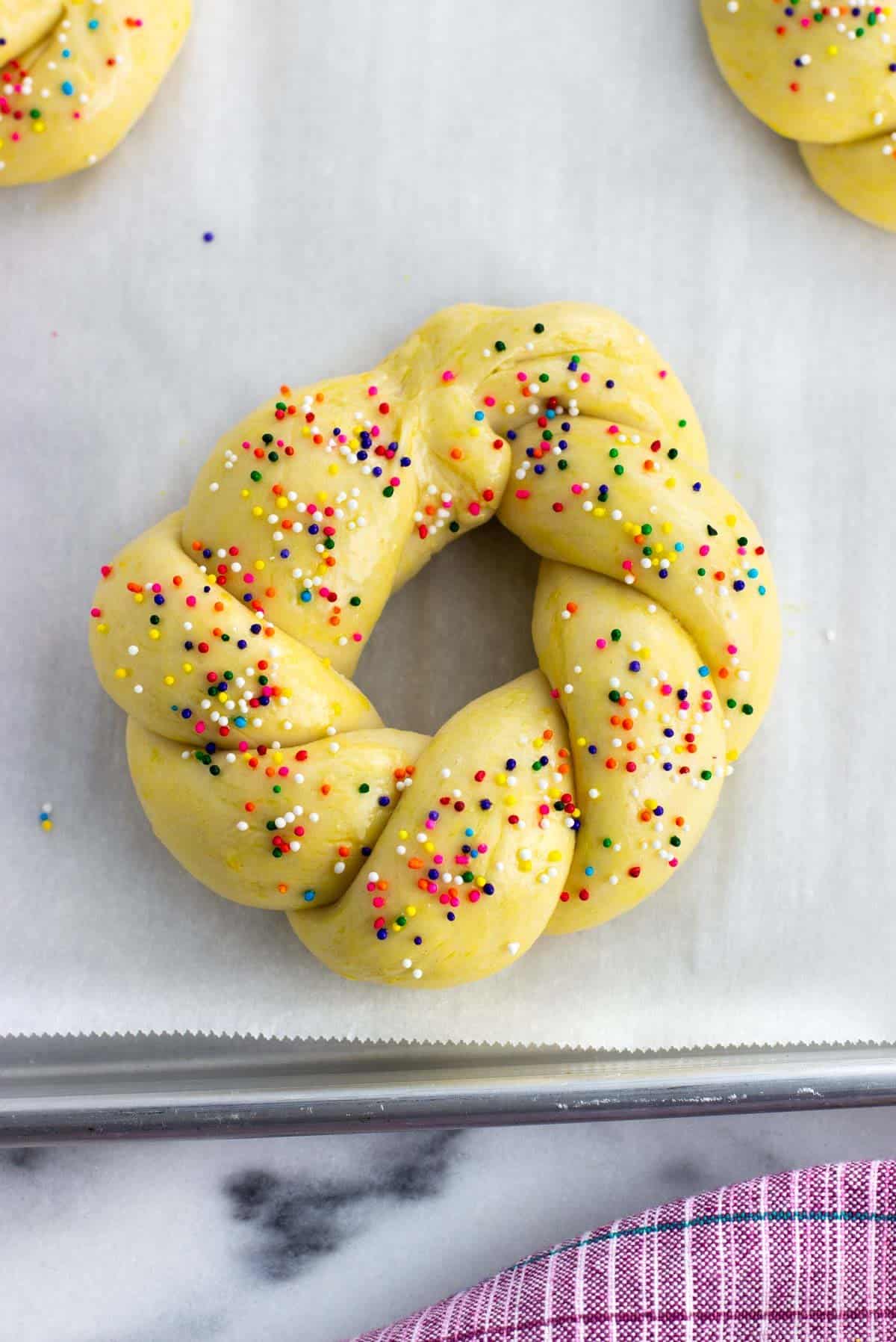 A ring of dough brushed with egg and nonpareils.