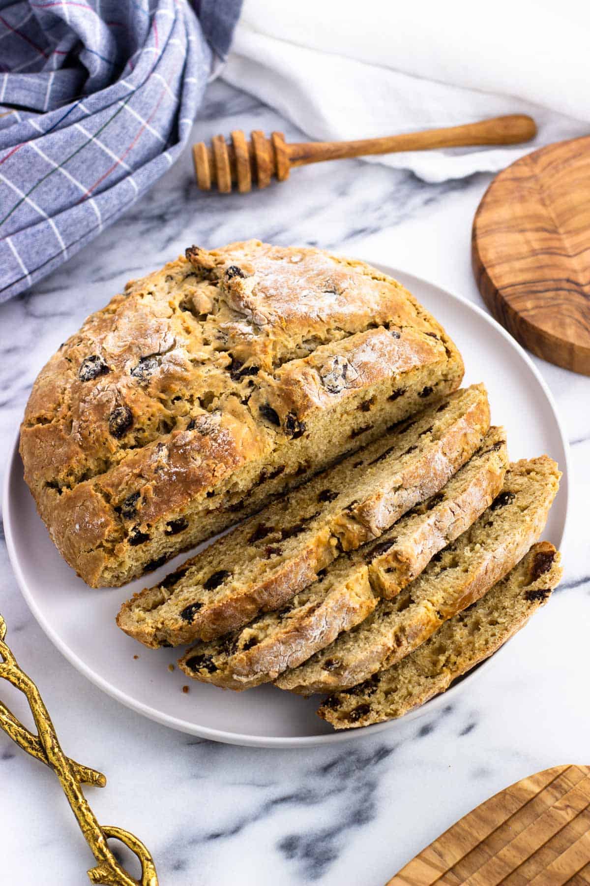 A half-sliced loaf of maple Irish soda bread on a plate.