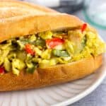 Scrambled eggs and peppers and onions on a roll.