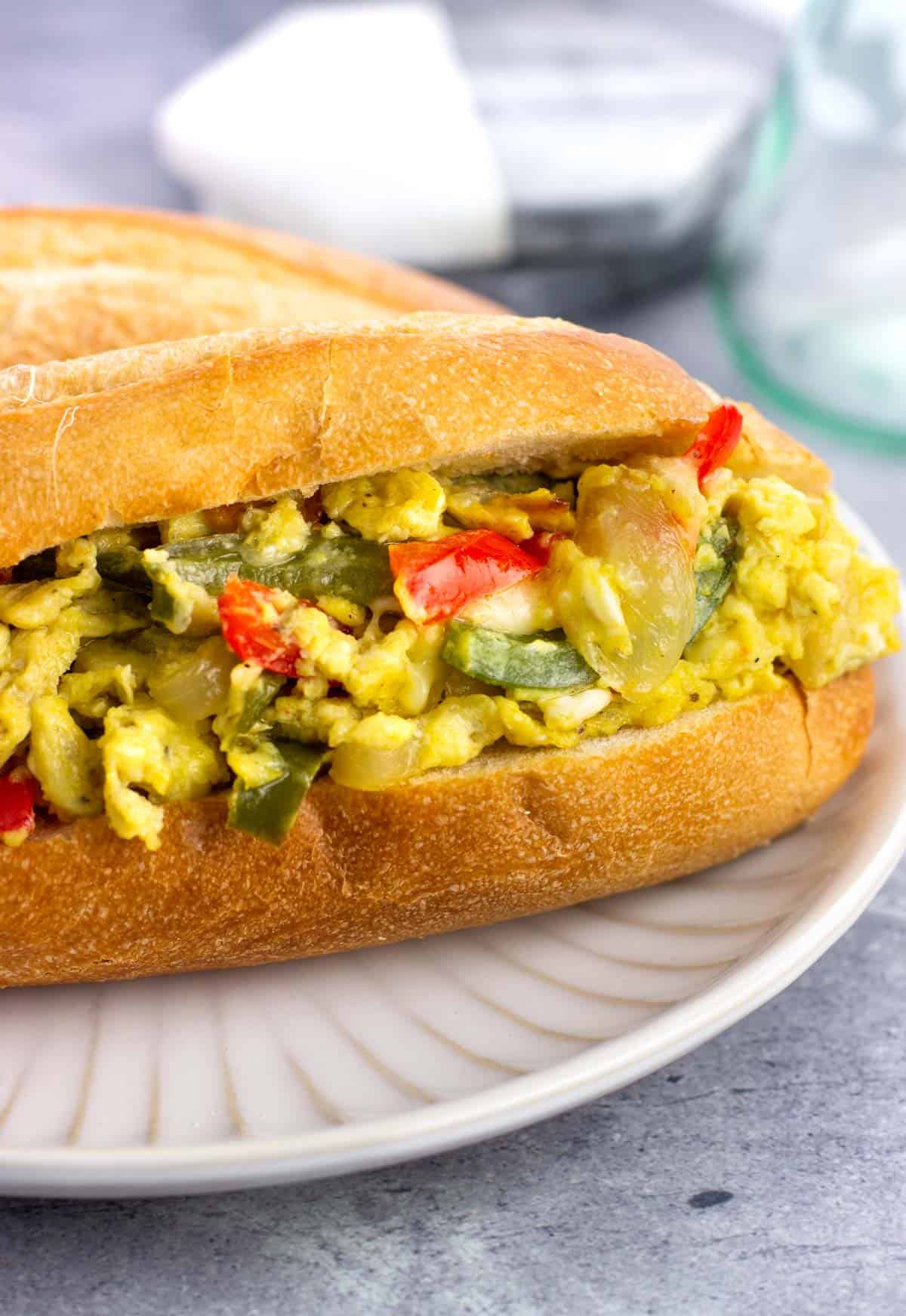 Scrambled eggs and peppers and onions on a roll.
