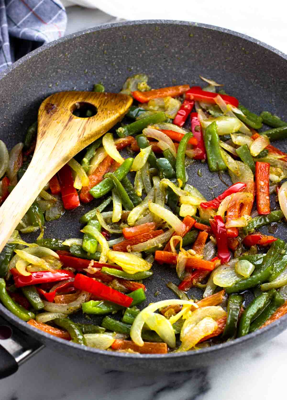 Sauteed peppers, onions, and garlic in a skillet.