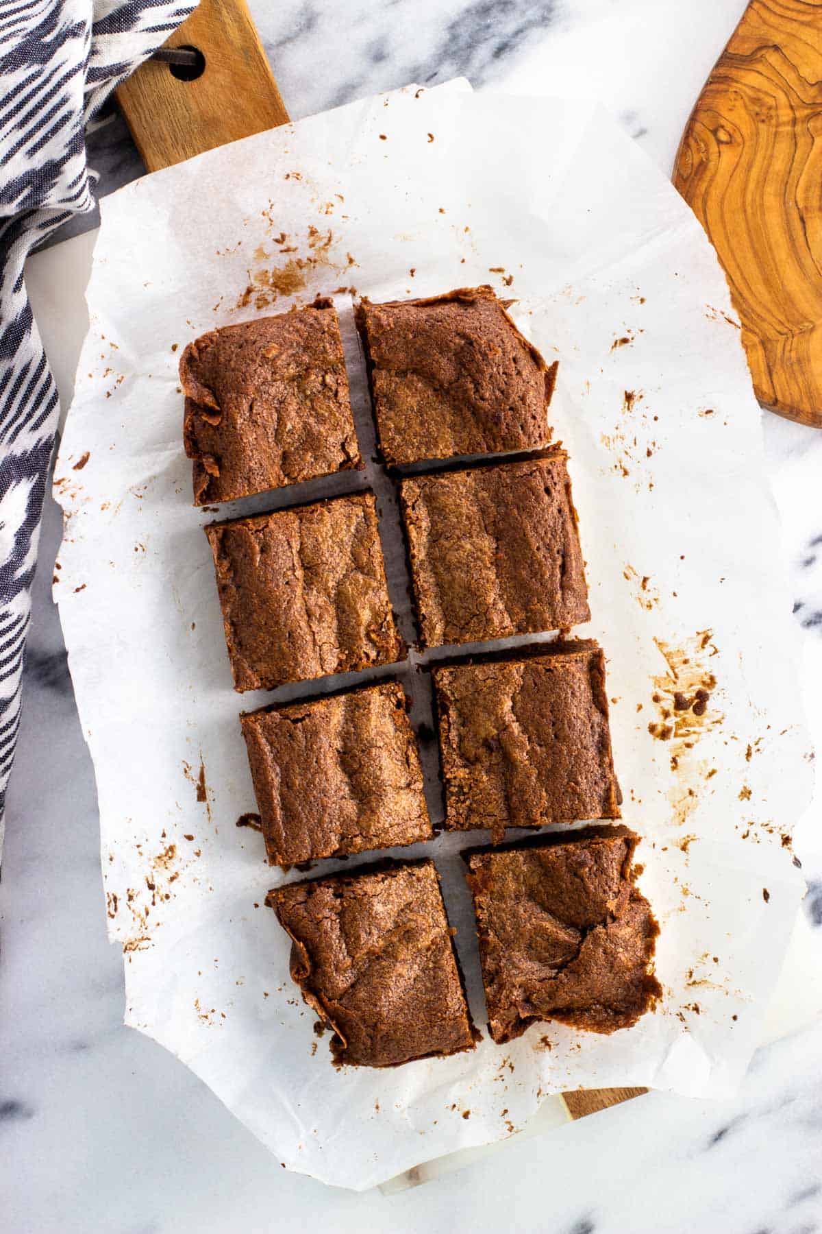 Eight brownies on a piece of parchment paper.