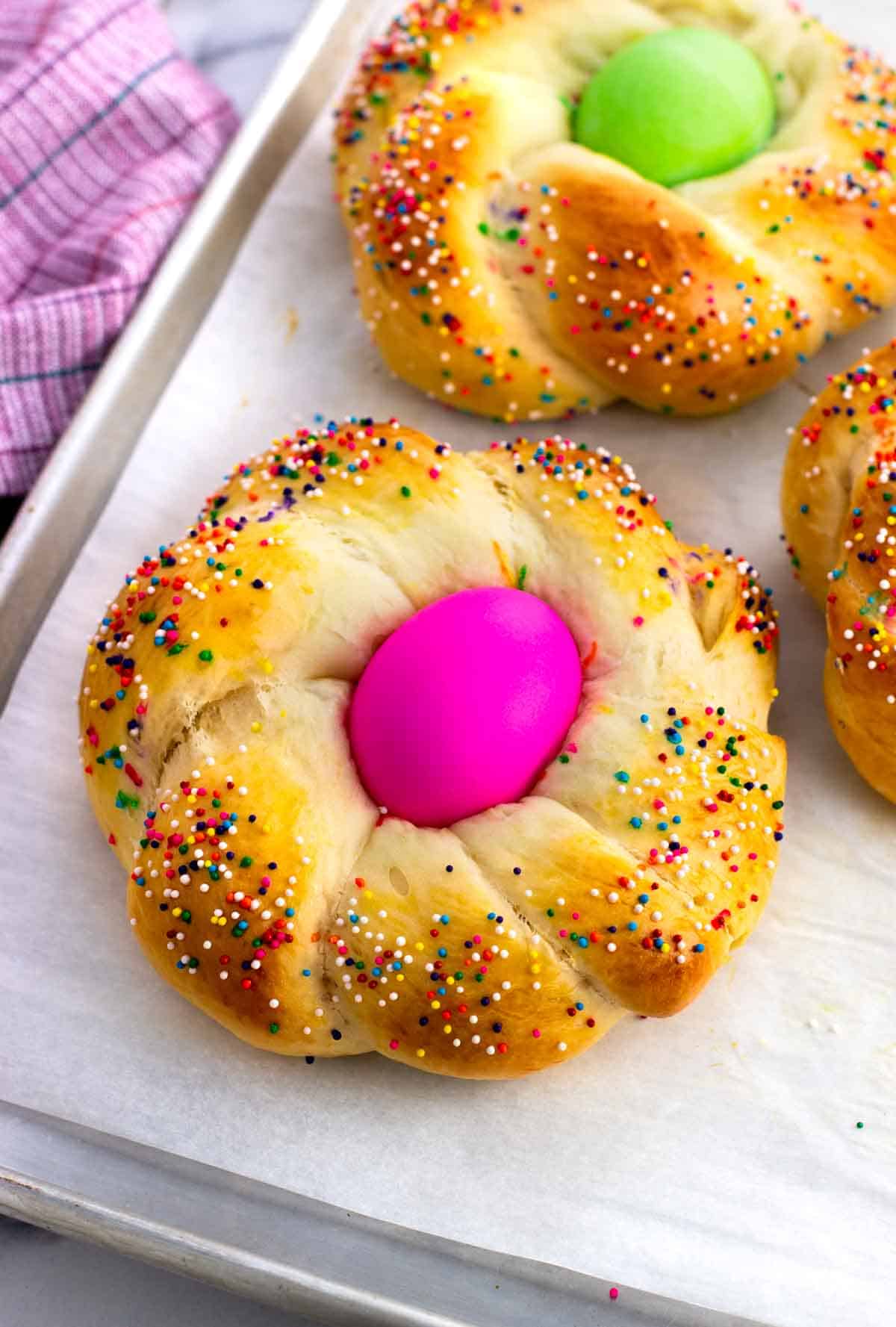 A baked Italian Easter bread loaf with an Easter egg in the middle.