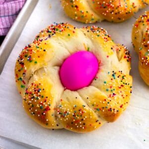 A baked Italian Easter bread loaf with an Easter egg in the middle.