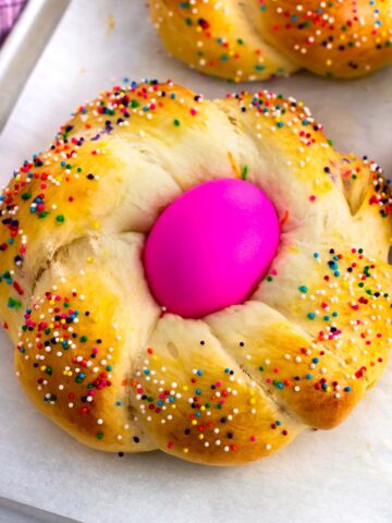 A baked Italian Easter bread loaf with an Easter egg in the middle.