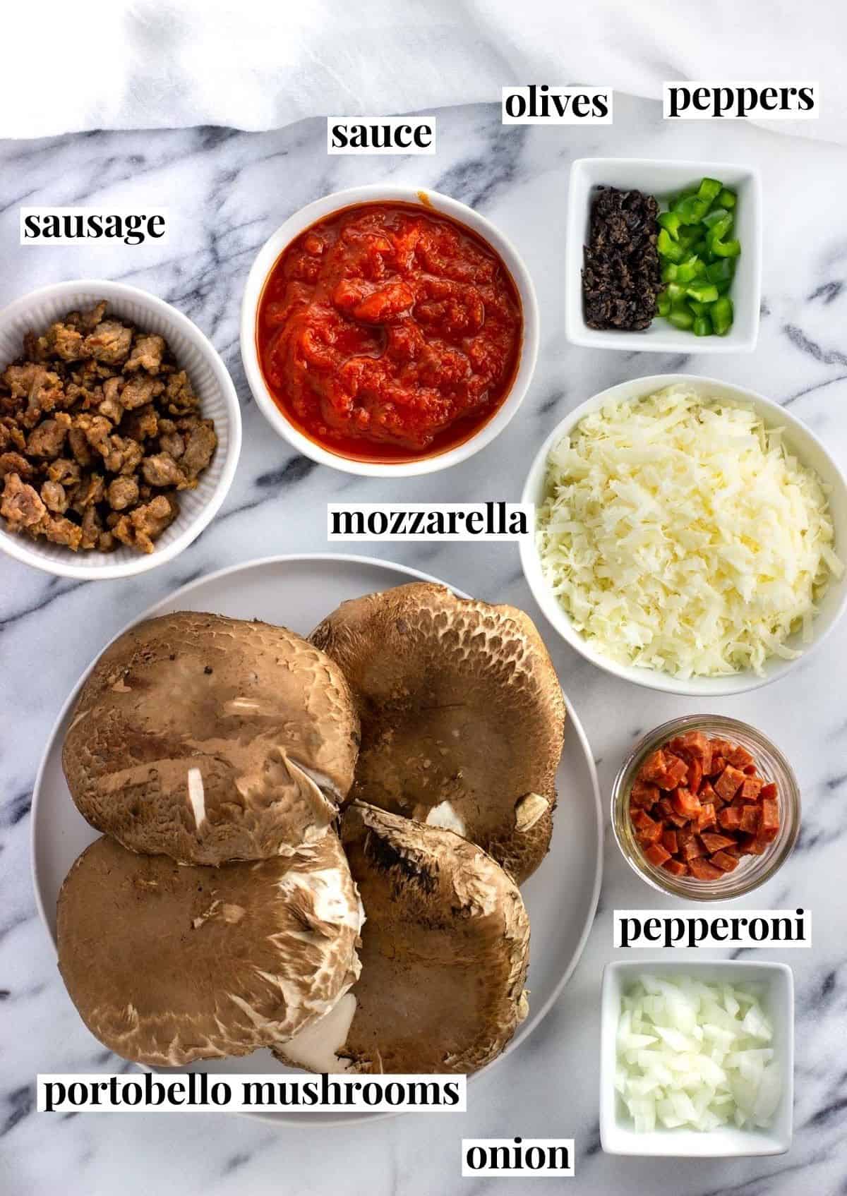 Labeled portobello mushroom pizza ingredients on a marble board.