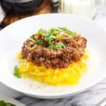 Bolognese served over spaghetti squash and garnished with basil.