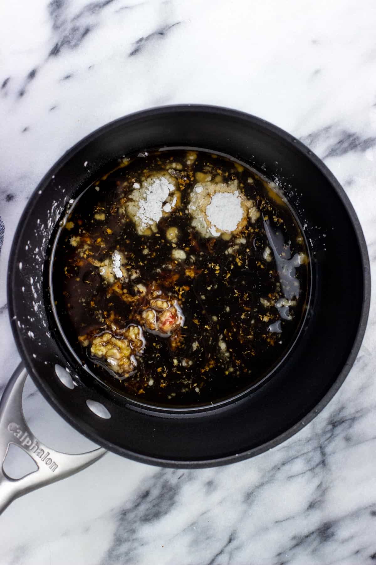 Air fryer tofu sauce ingredients added to a pan.