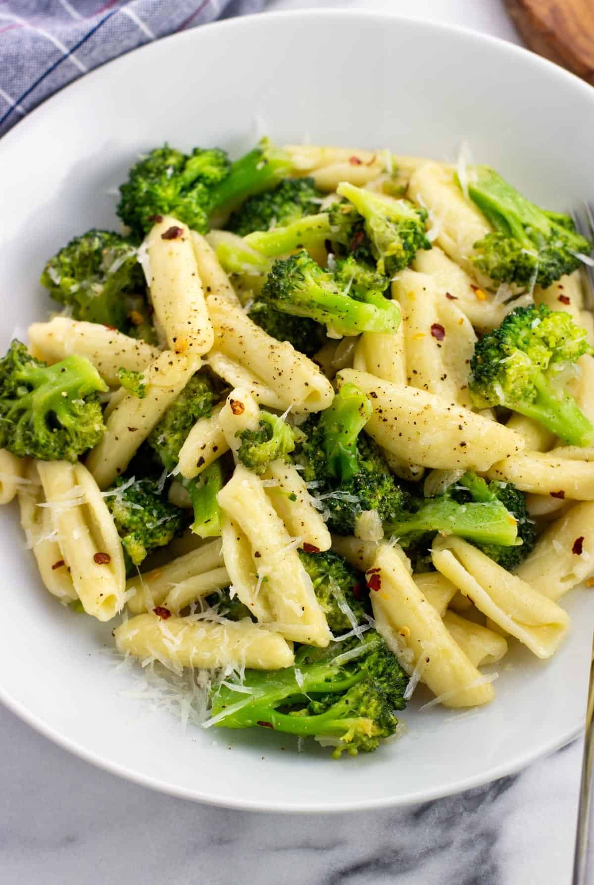 A plate of cavatelli and broccoli topped with Pecorino and crushed red pepper.