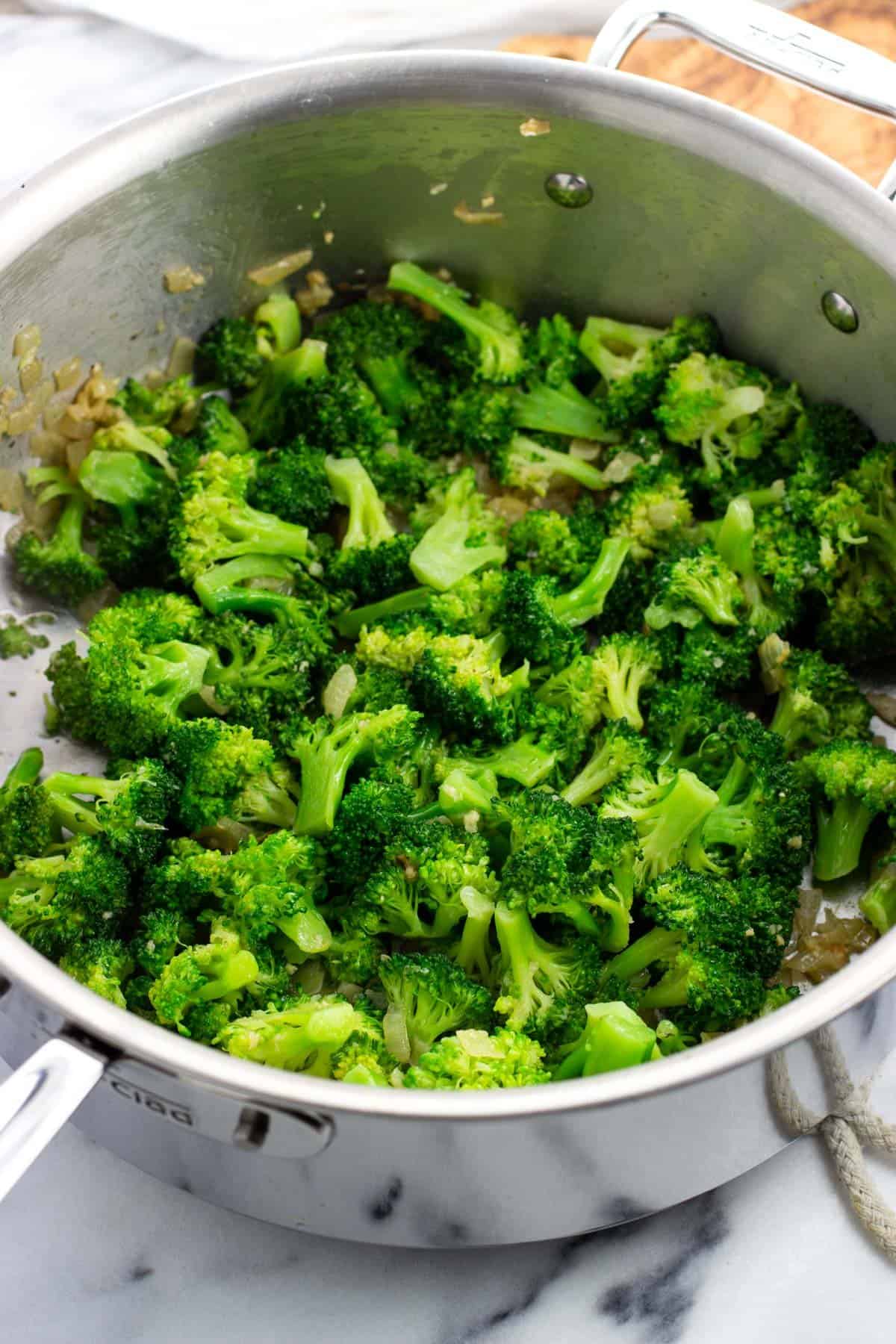 Blanched broccoli added to the pan.