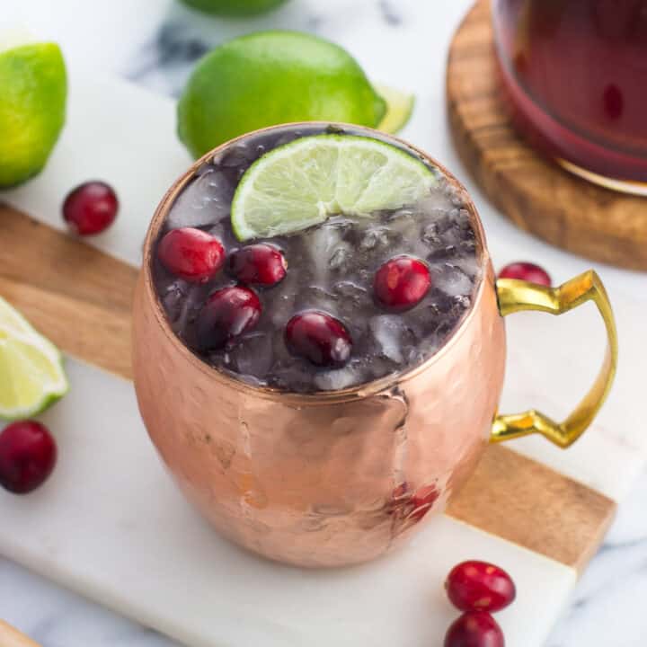 A frosty cranberry moscow mule in a copper mug.