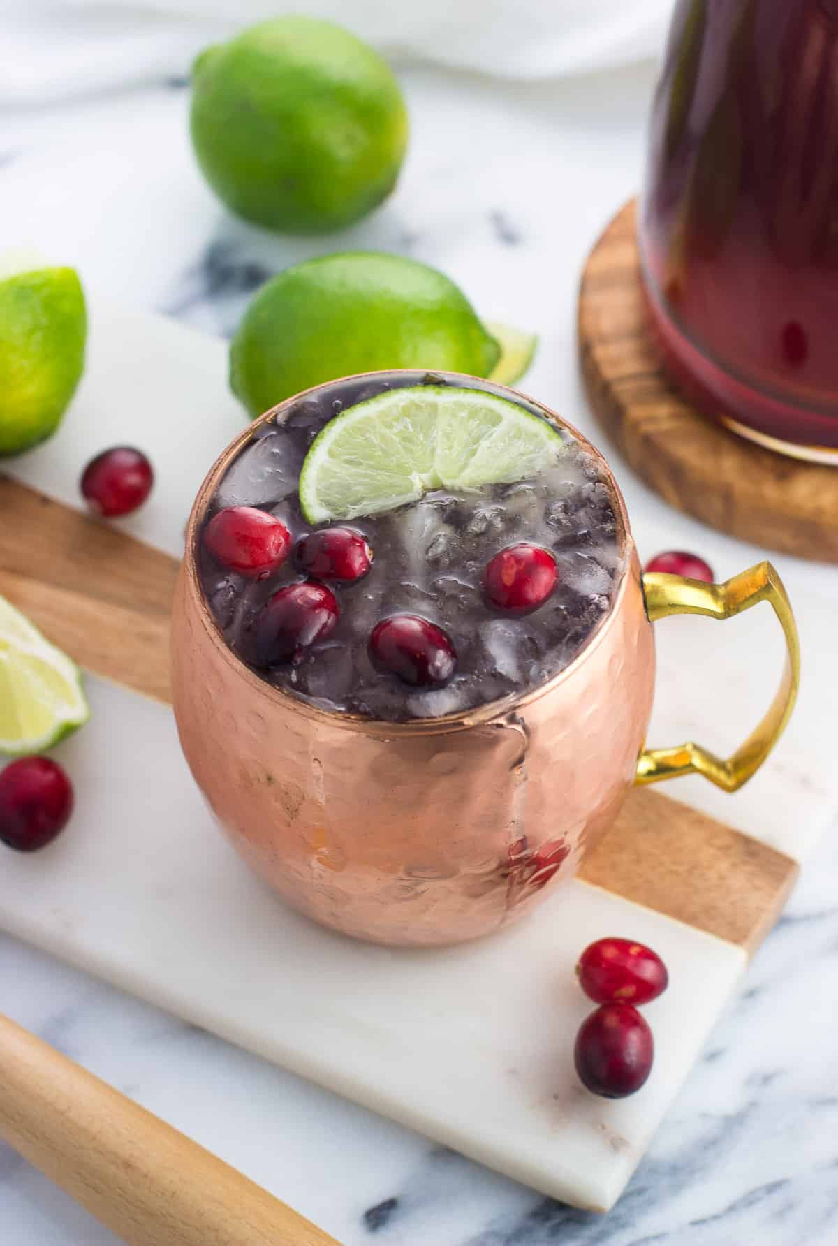 A frosty cranberry moscow mule in a copper mug.