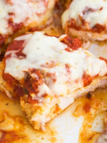 Baked chicken parmesan in a pan cut in half.