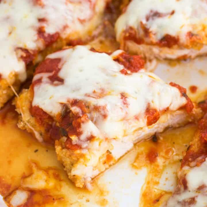 Baked chicken parmesan in a pan cut in half.