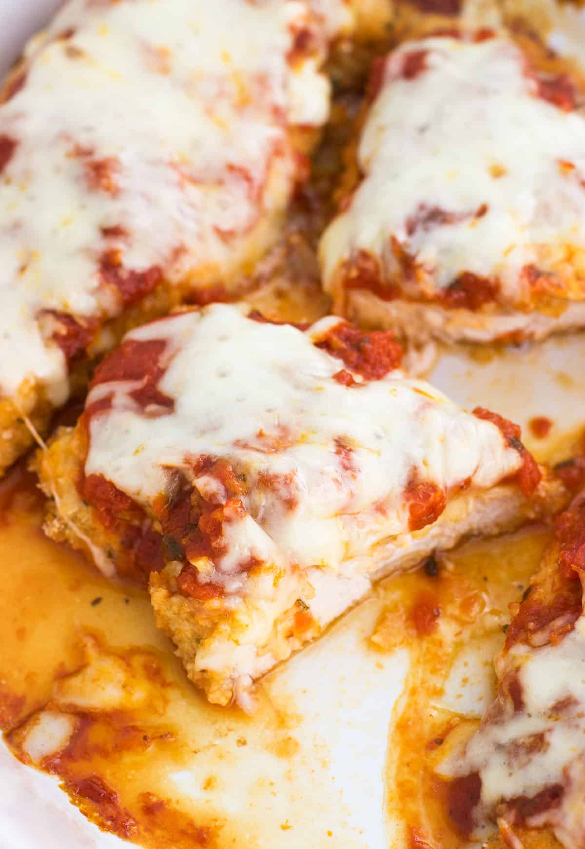 Baked chicken parmesan in a pan cut in half.