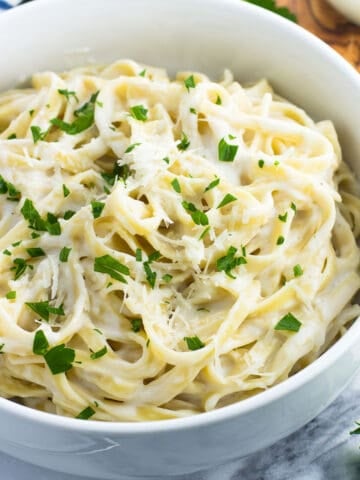 A bowl of healthy alfredo sauce coating fettuccine.