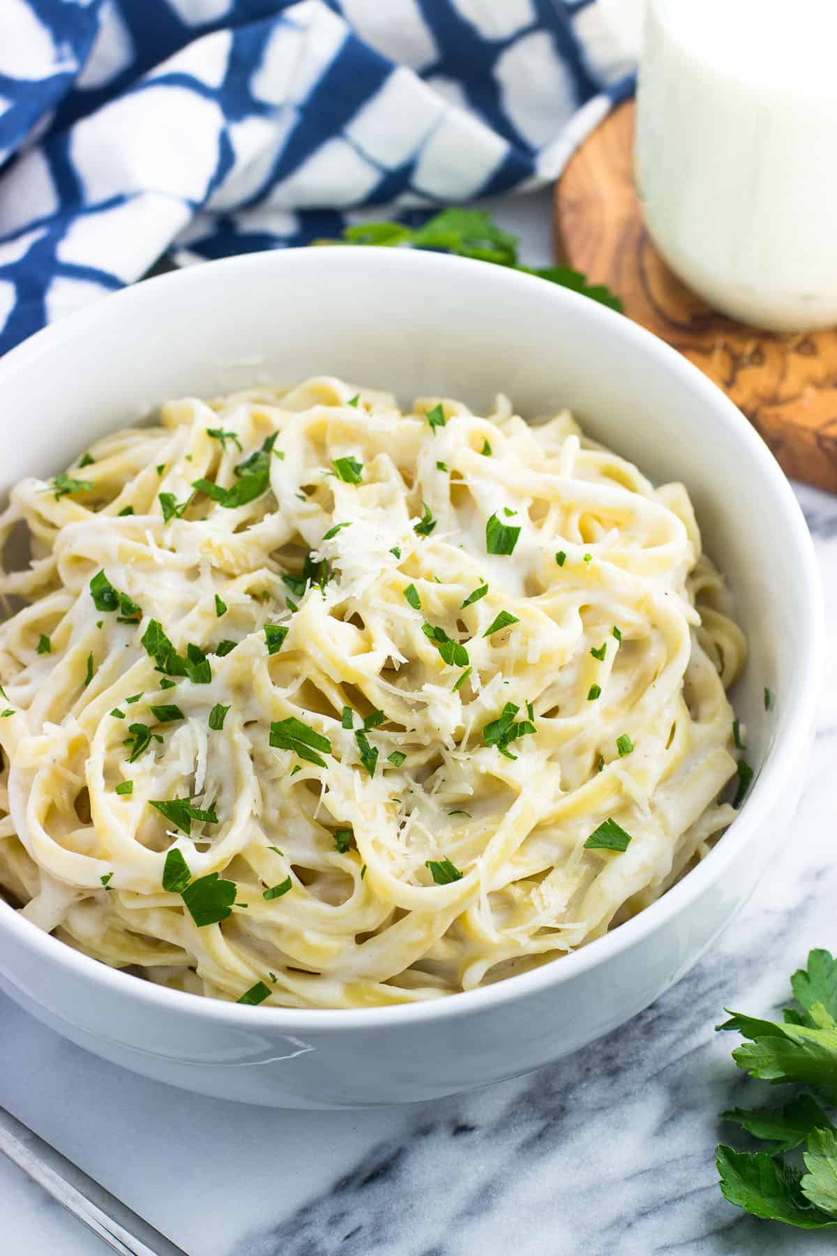 A bowl of healthy alfredo sauce coating fettuccine.