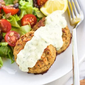 Baked tuna cakes on a plate with a salad.