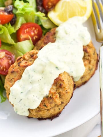 Baked tuna cakes on a plate with a salad.