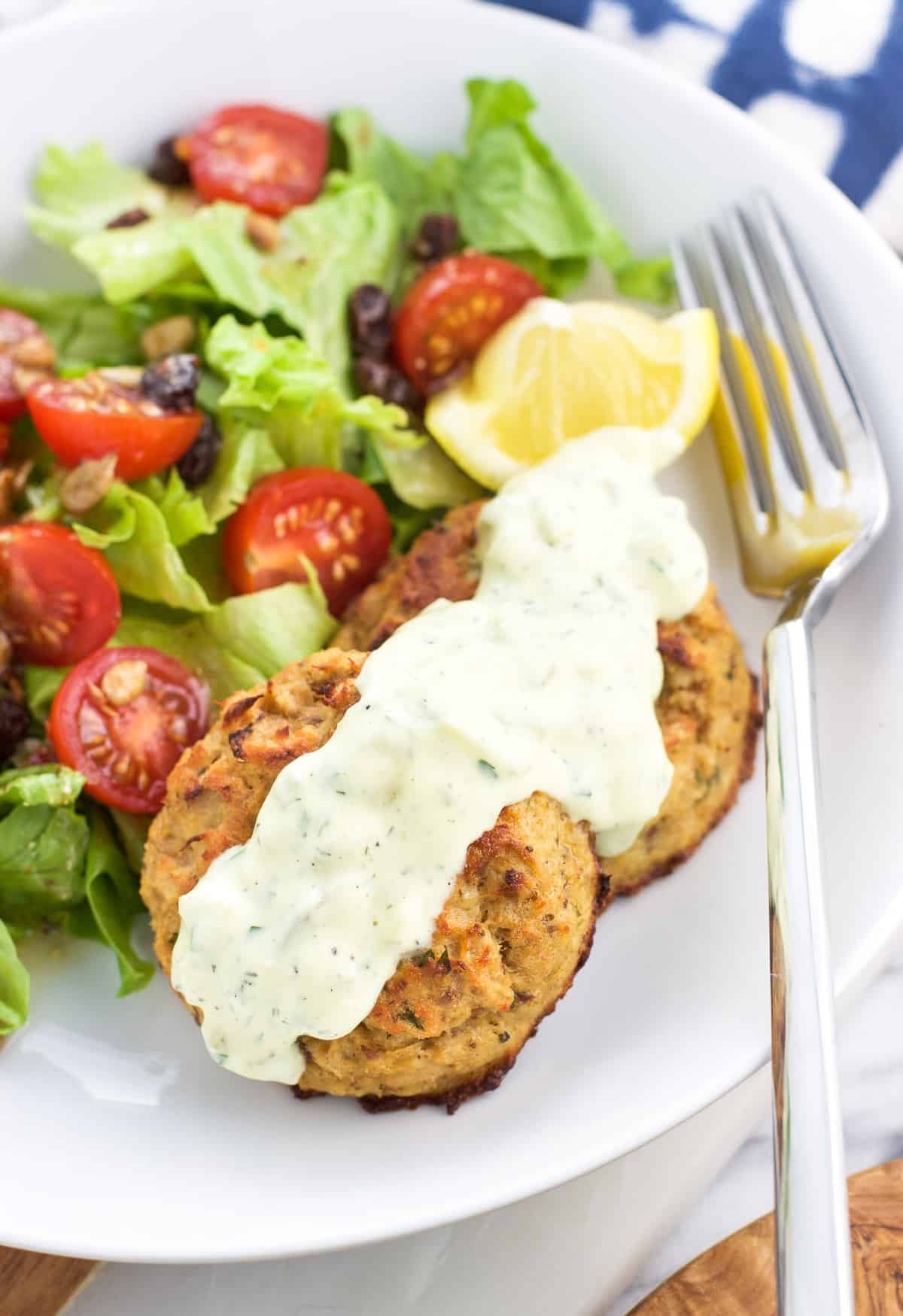 Baked tuna cakes on a plate with a salad.
