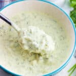 A spoon lifting out healthy tartar sauce from a bowl.