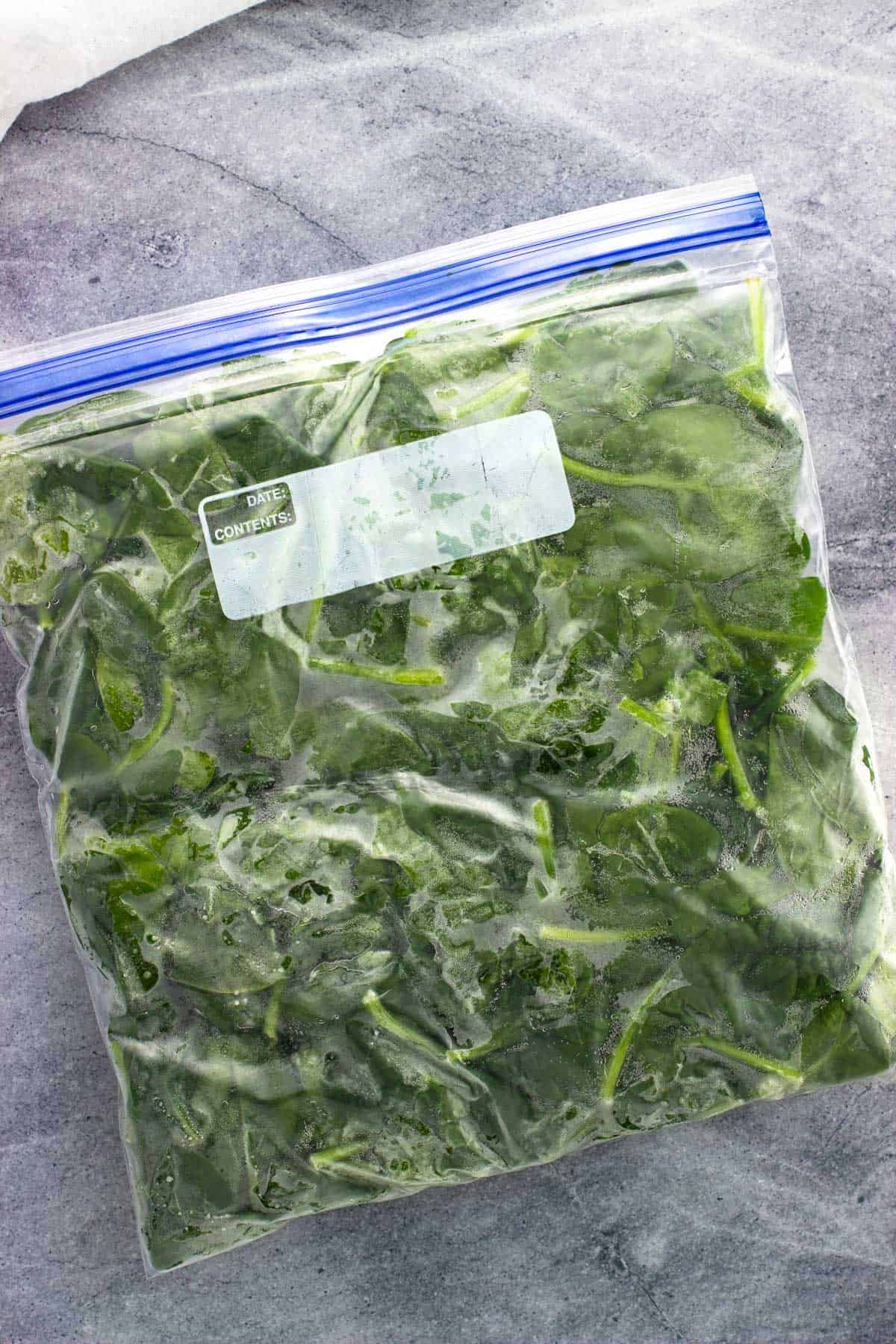 Frozen spinach leaves in a sealed plastic bag.