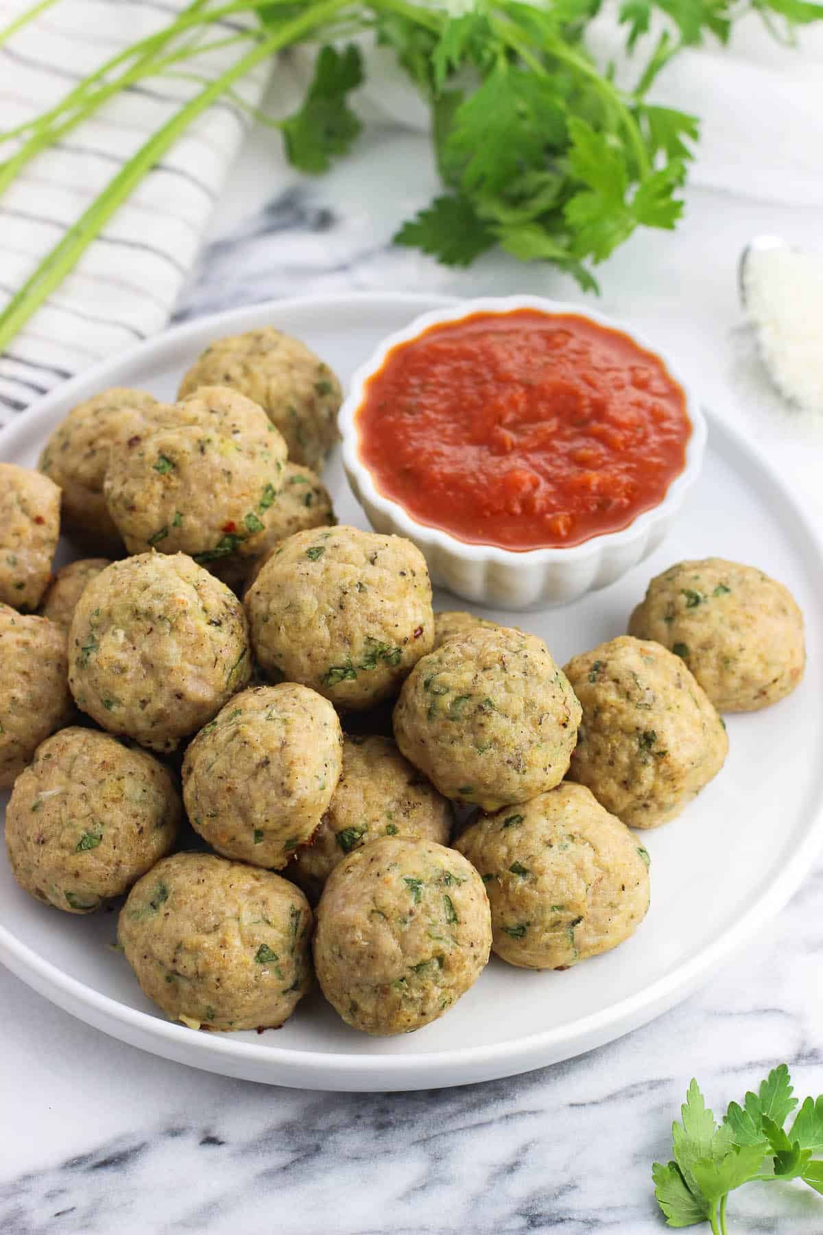 A plate of Italian turkey meatballs with marinara dipping sauce.