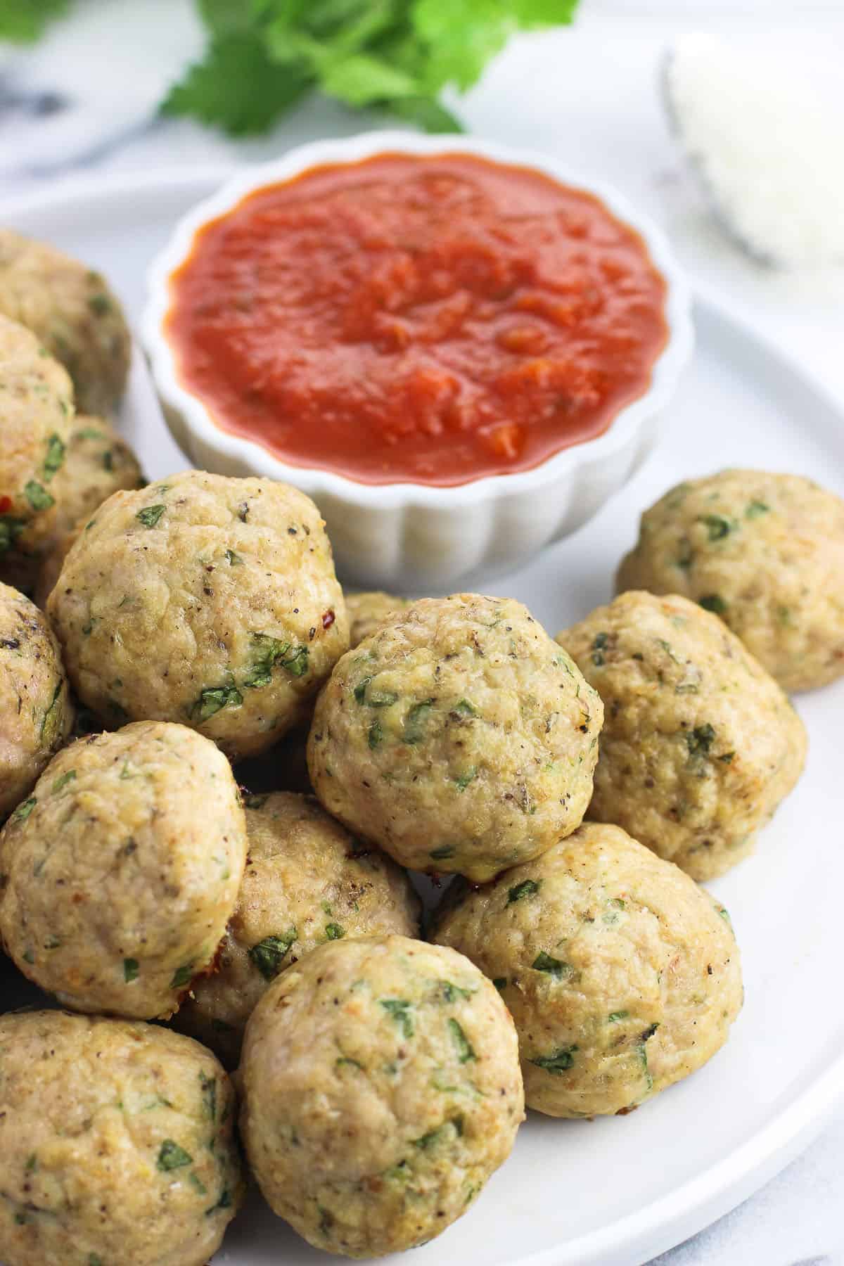 A plate of Italian turkey meatballs with marinara dipping sauce.