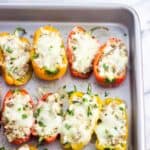 Stuffed mini peppers on a baking sheet.