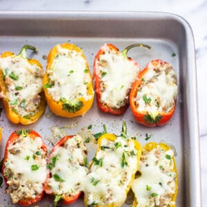 Stuffed mini peppers on a baking sheet.