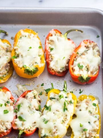 Stuffed mini peppers on a baking sheet.