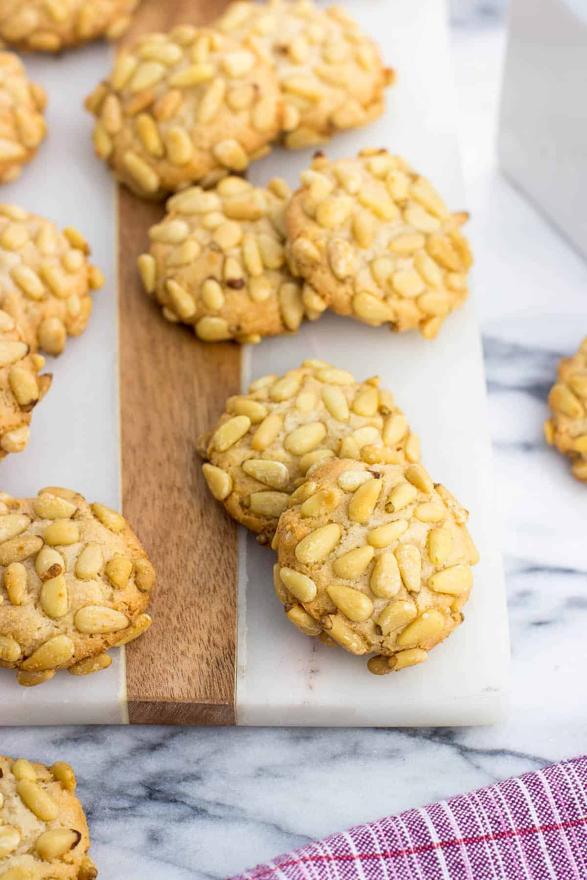 Pignoli cookies on a marble serving board.