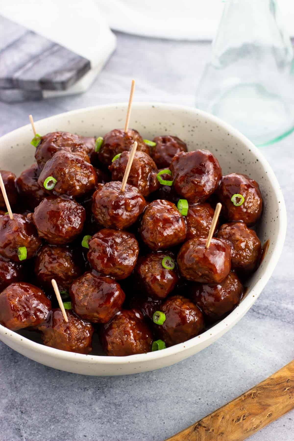 A bowl of cocktail meatballs with toothpicks in them.