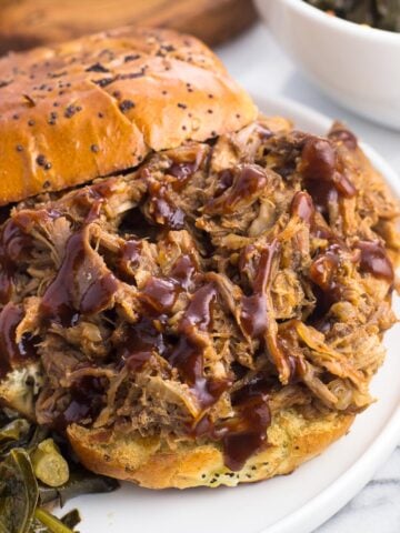 A pulled pork sandwich drizzled with BBQ sauce.