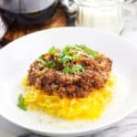 Spaghetti squash bolognese topped with fresh basil.