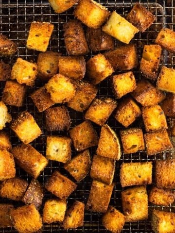 Air fryer croutons on a wire air fryer basket.