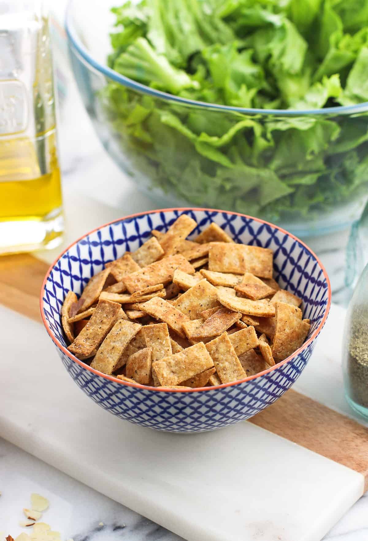 Baked tortilla strips in a small ceramic bowl.