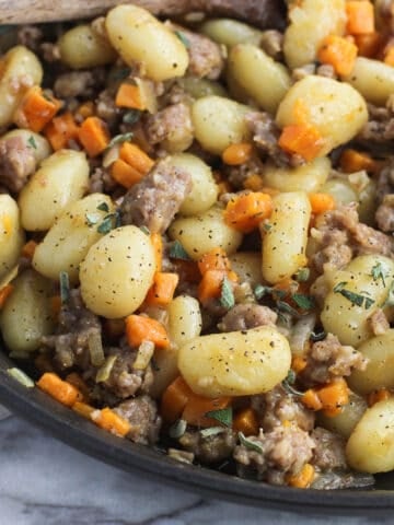 Maple sausage, gnocchi, and sweet potato in a skillet.