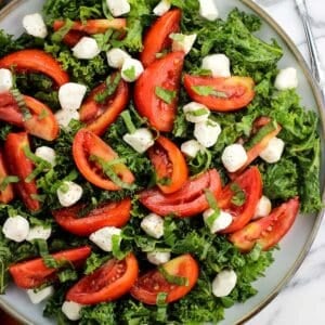 A marinated kale caprese salad on a plate.