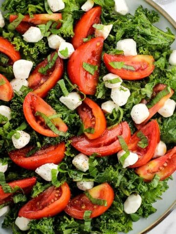 A marinated kale caprese salad on a plate.