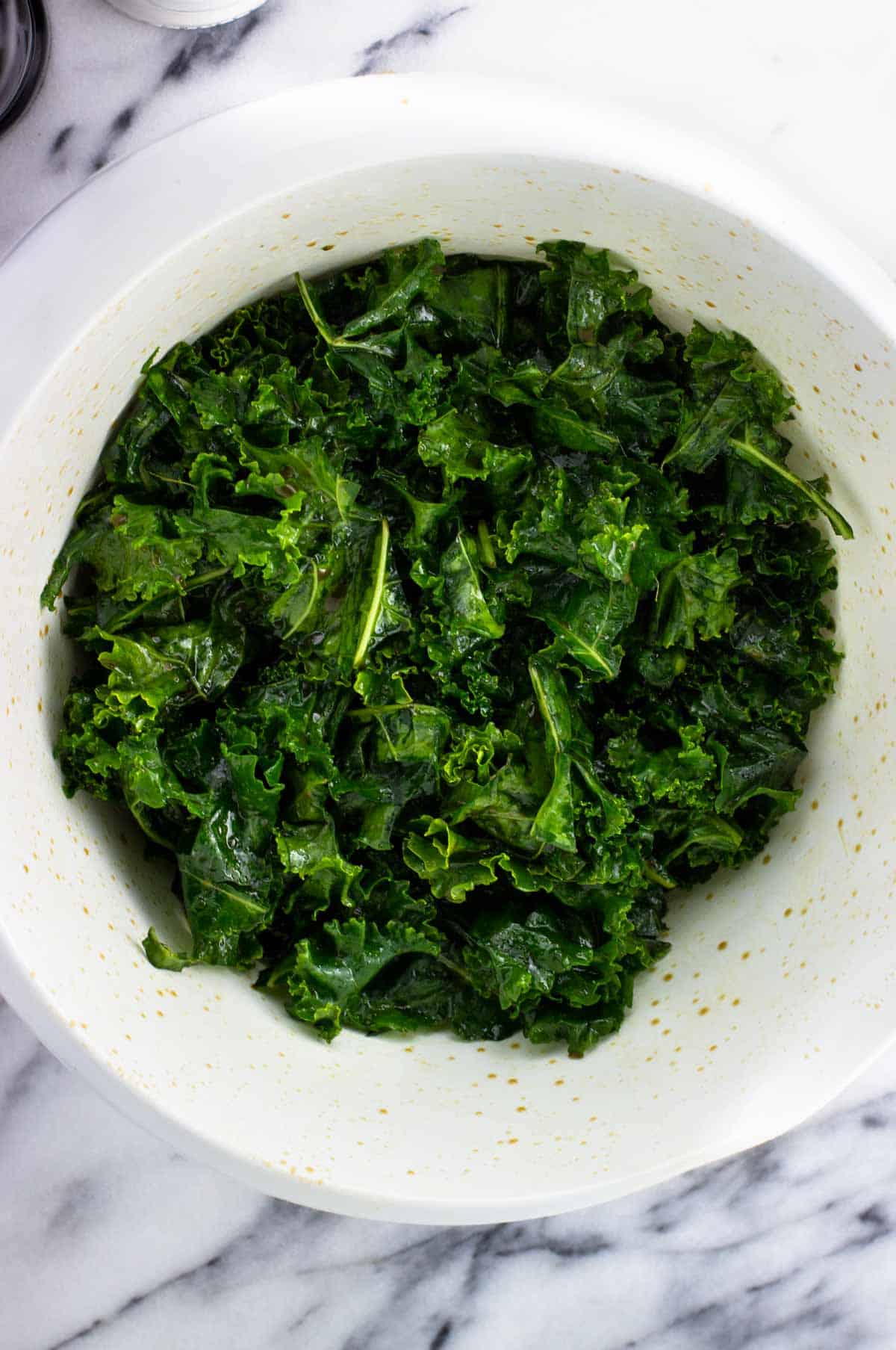 Massaged kale in a big plastic bowl.