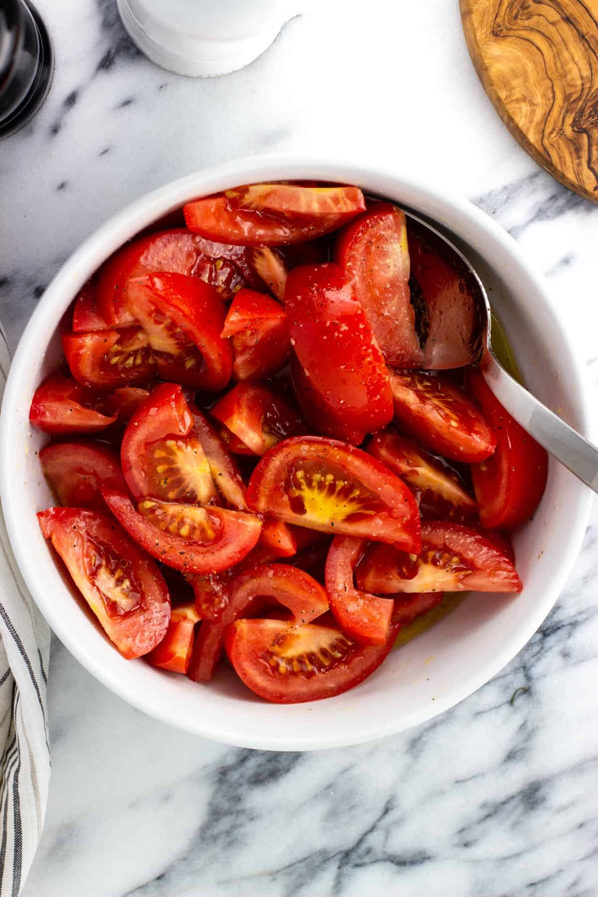 Marinating tomato wedges in a bowl.